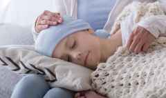 Caregiver supporting sleeping sick child with cancer in the hospice