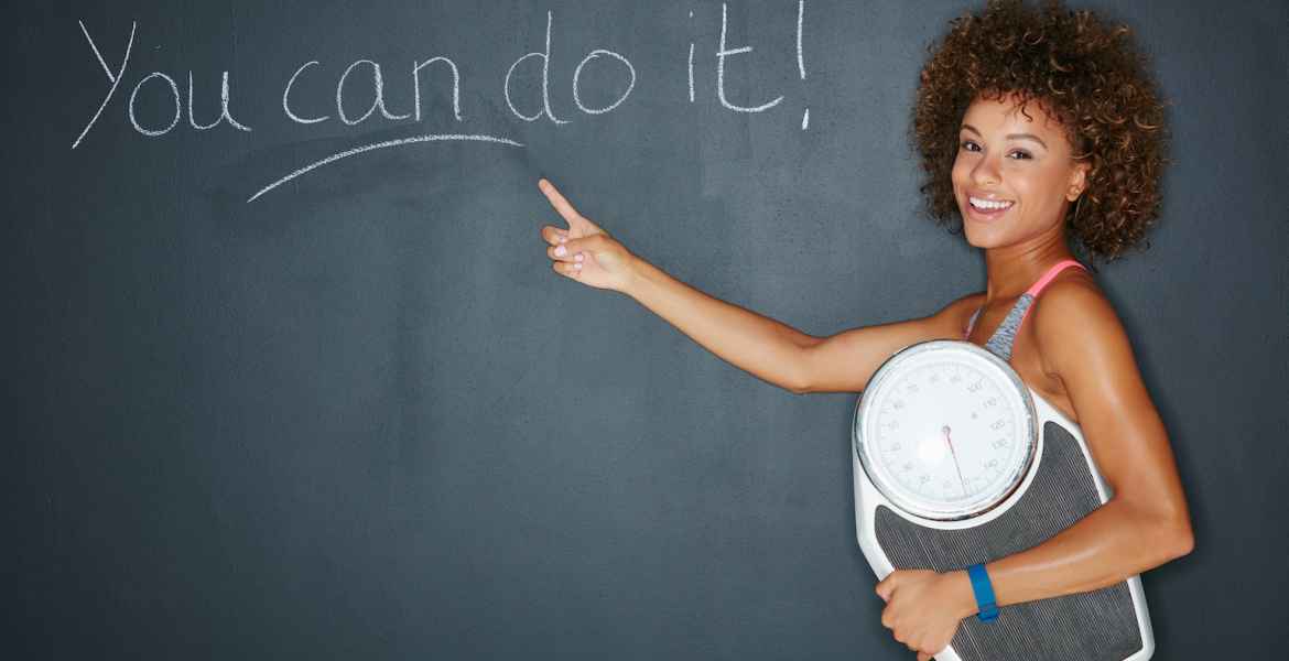 shot of a woman holding a scale against a chalk background with a motivational message