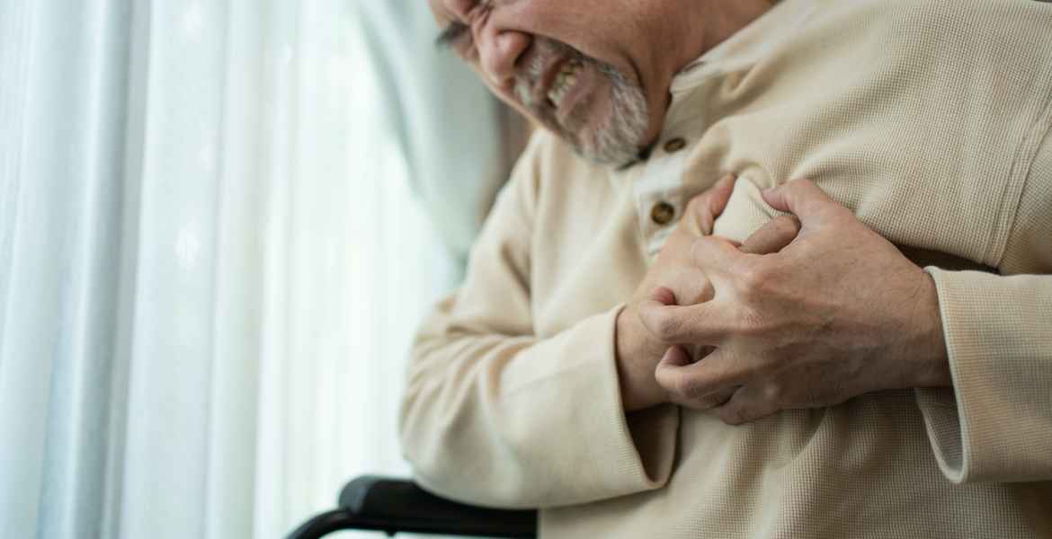 senior disabled male with chest pain suffer from heart attack. elderly older male on wheelchair has difficulty breath clutching his chest from acute pain. hospital healthcare and medical concept