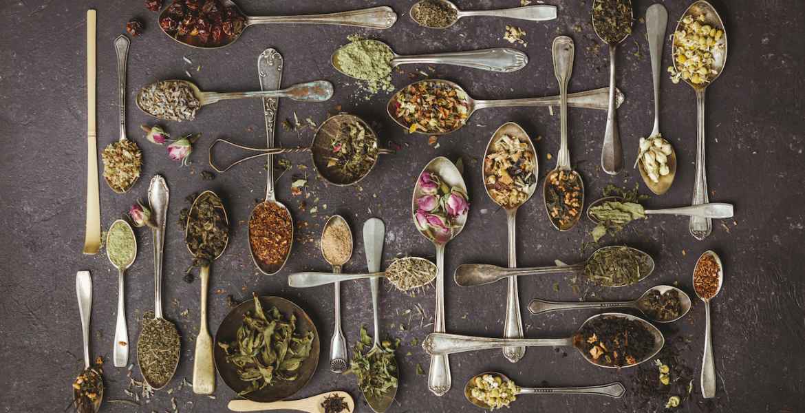 assortment of dry tea in vintage spoons