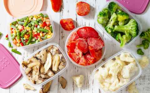 stocks of food for the winter. container with frozen vegetables and mushrooms. top view flat lay background