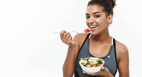 healthy and fitness concept beautiful american african lady in fitness clothes on diet eating fresh salad.